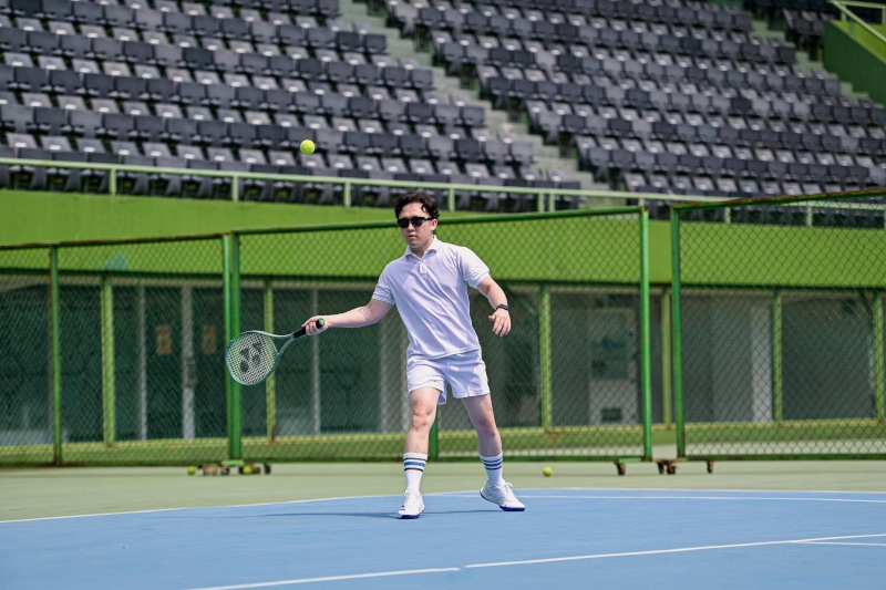 Danu playing a forehand on an outdoor tennis court